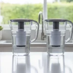 Brita and PUR water filter pitchers side by side on a kitchen counter
